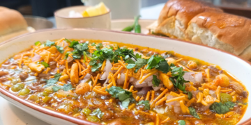 Quick and easy Kolhapuri Misal Pav made with sprouted moth beans and green peas, topped with crunchy namkeen and served with buttery pav